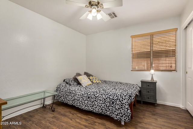 bedroom featuring visible vents, baseboards, ceiling fan, and wood finished floors