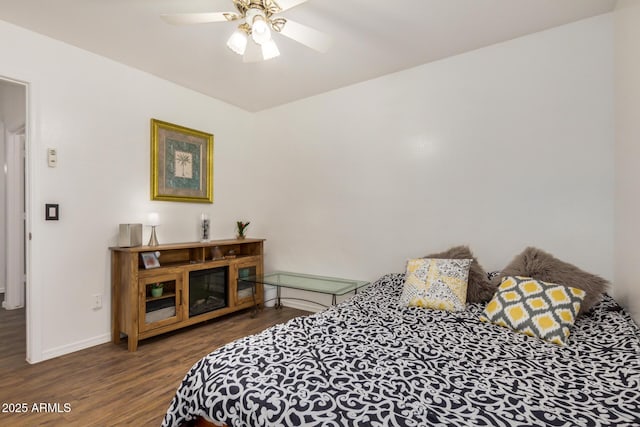 bedroom with baseboards, ceiling fan, and wood finished floors