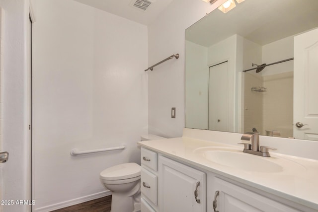 bathroom featuring visible vents, vanity, wood finished floors, toilet, and walk in shower