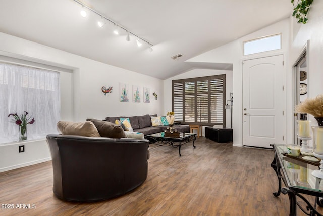 living room featuring track lighting, plenty of natural light, wood finished floors, and vaulted ceiling