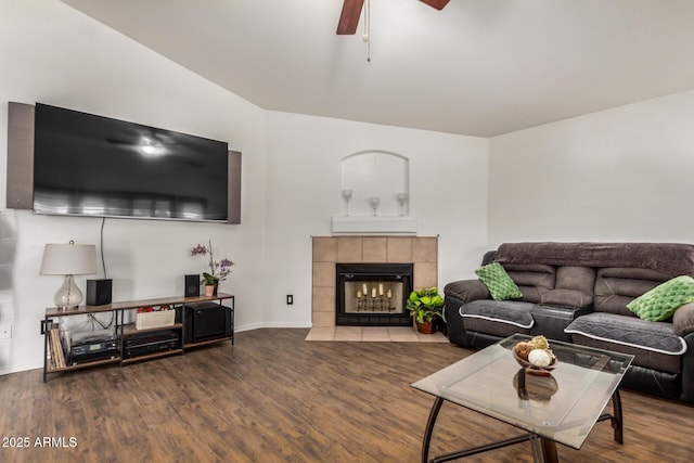 living room featuring baseboards, a ceiling fan, wood finished floors, and a tile fireplace