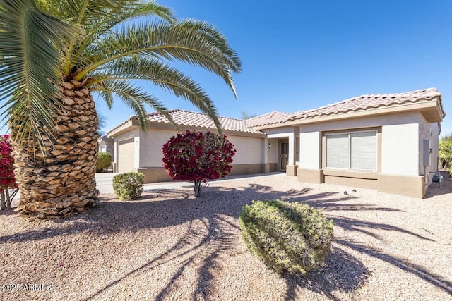 view of front of home with a garage, a tiled roof, and stucco siding