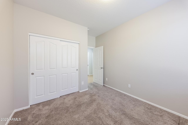 unfurnished bedroom with a closet and light colored carpet