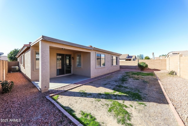 rear view of house featuring central air condition unit and a patio