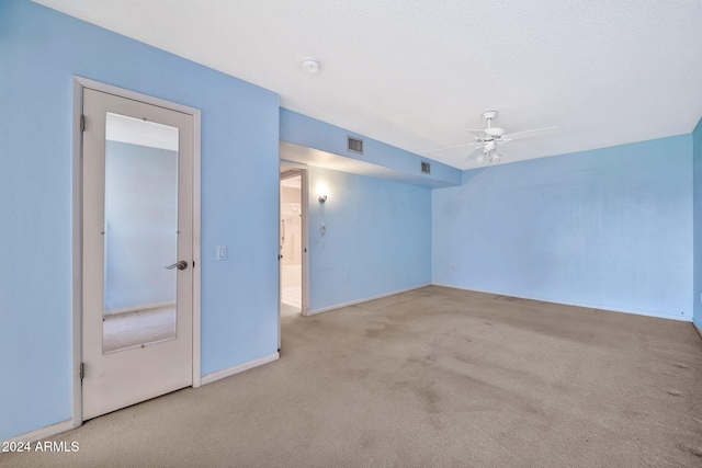 unfurnished room with light carpet, a textured ceiling, and ceiling fan