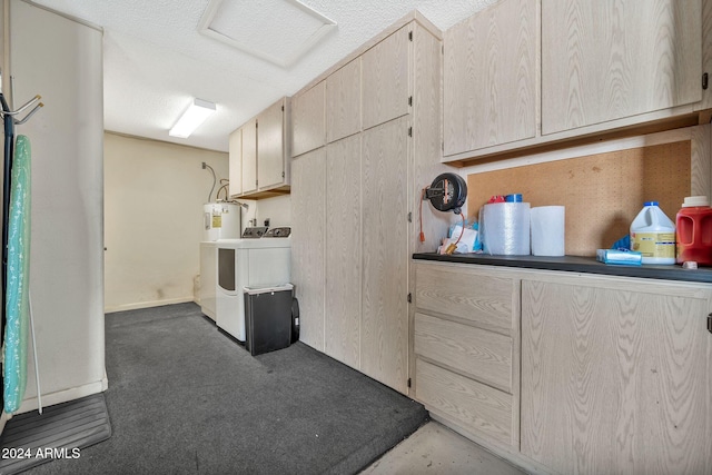 washroom with cabinets, dark carpet, a textured ceiling, electric water heater, and washer and clothes dryer