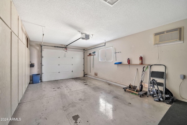 garage featuring an AC wall unit and a garage door opener