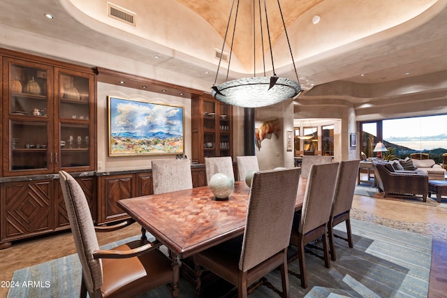 dining space with dark tile floors and a tray ceiling