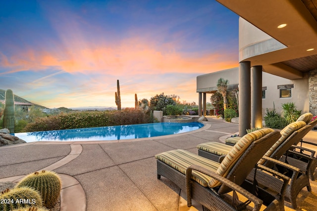 pool at dusk featuring a patio area