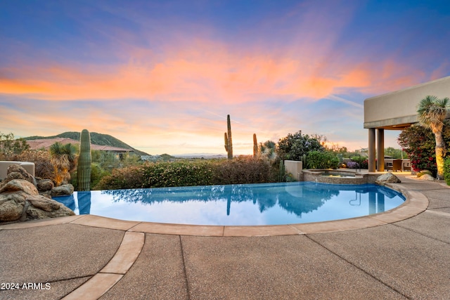 pool at dusk featuring a patio