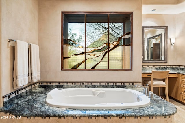 bathroom with vanity and tiled tub