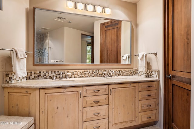 bathroom with tasteful backsplash and dual bowl vanity