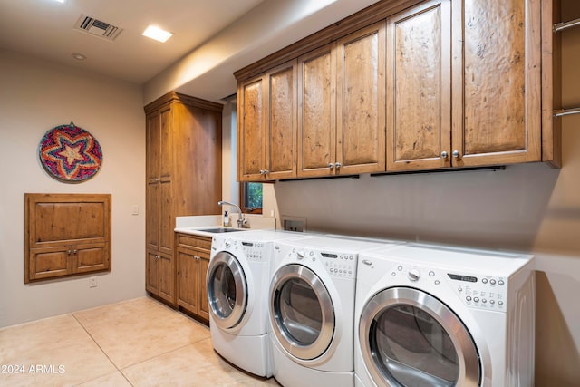 laundry area featuring light tile floors, washer and dryer, sink, washer hookup, and cabinets