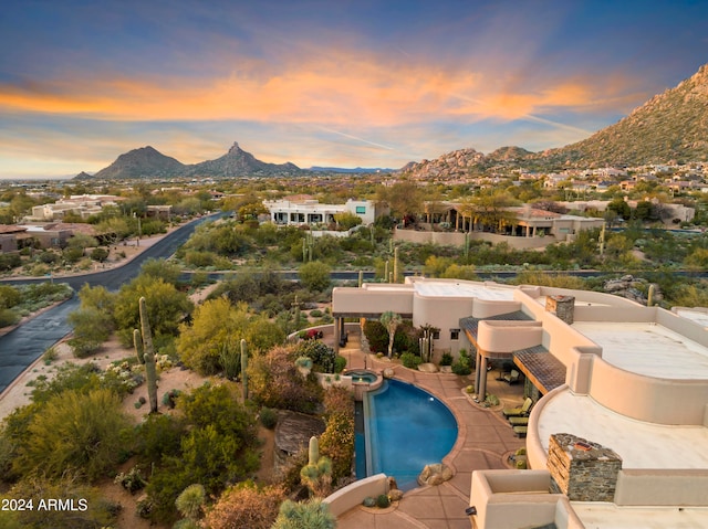 pool at dusk with a patio and a mountain view