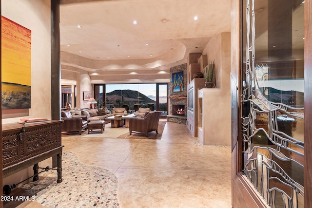 living room with a raised ceiling, a fireplace, and a mountain view