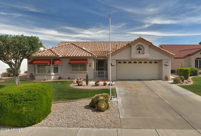 mediterranean / spanish house featuring a front lawn and a garage