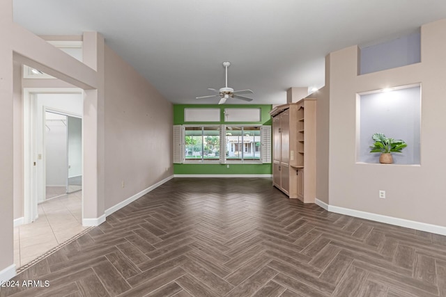 unfurnished living room featuring ceiling fan and dark parquet flooring