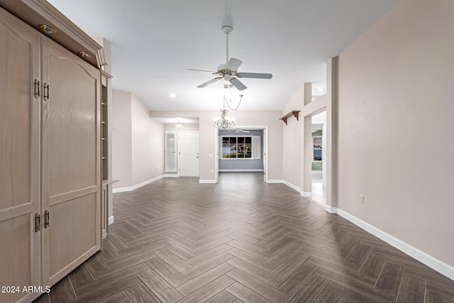 unfurnished living room featuring ceiling fan with notable chandelier and dark parquet floors