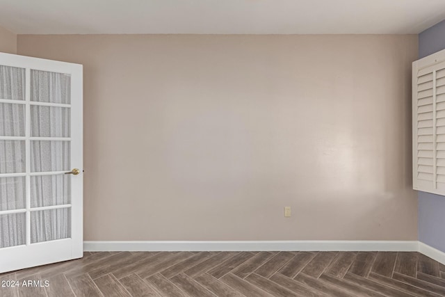 spare room featuring dark parquet floors