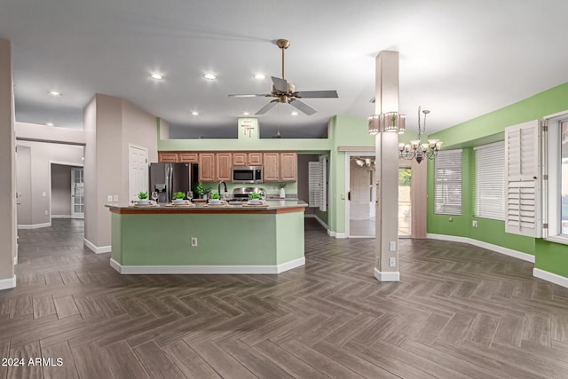 kitchen featuring dark parquet floors, high vaulted ceiling, stainless steel appliances, and ceiling fan with notable chandelier