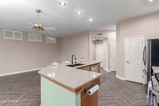 kitchen with sink, dark parquet flooring, a kitchen island with sink, and stainless steel appliances