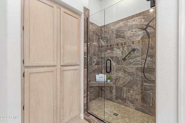 bathroom featuring a shower with shower door