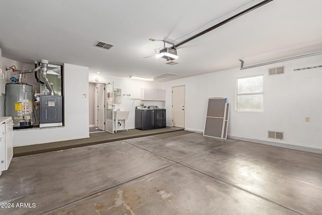 garage featuring washer and clothes dryer, a garage door opener, gas water heater, and sink