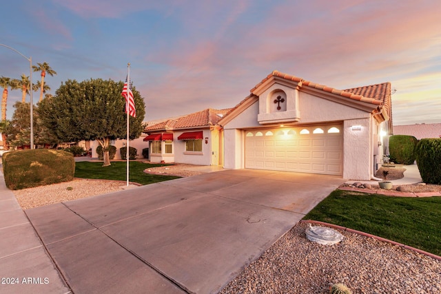 mediterranean / spanish home with a yard and a garage