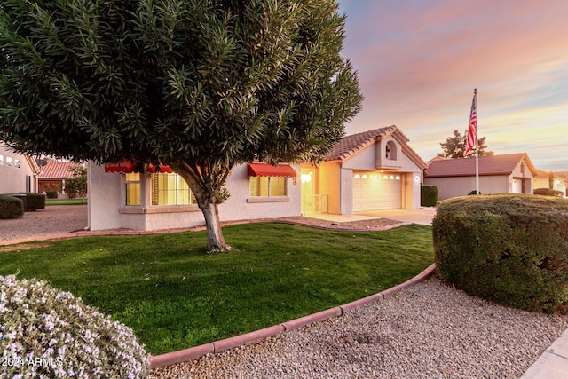 view of front of property with a lawn and a garage