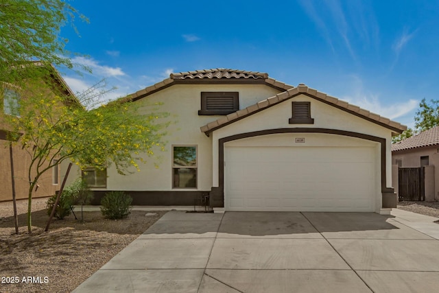 mediterranean / spanish-style house with stucco siding, a garage, and concrete driveway