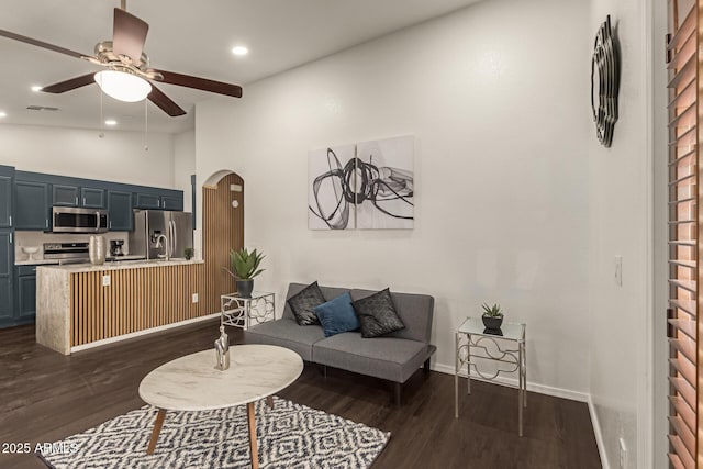 living room with visible vents, arched walkways, ceiling fan, dark wood finished floors, and recessed lighting