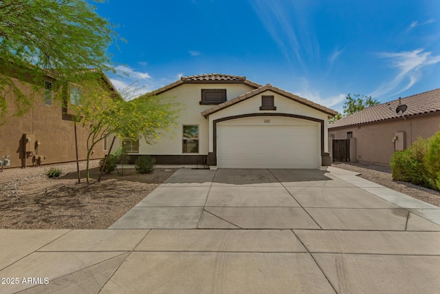mediterranean / spanish-style home featuring a tile roof, driveway, a garage, and stucco siding