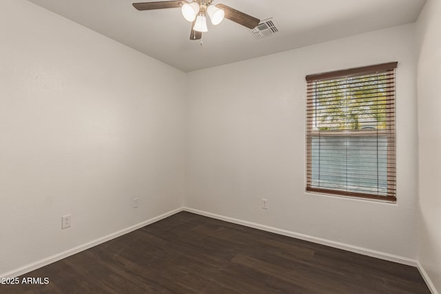 unfurnished room with dark wood-style flooring, visible vents, baseboards, and a ceiling fan