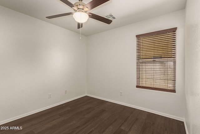 empty room with dark wood-style flooring, baseboards, visible vents, and ceiling fan