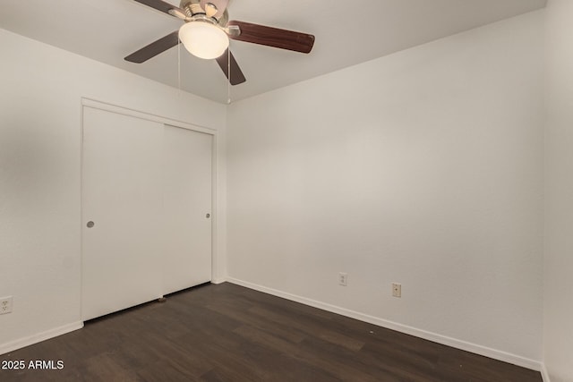 unfurnished bedroom featuring a closet, dark wood-style flooring, baseboards, and a ceiling fan