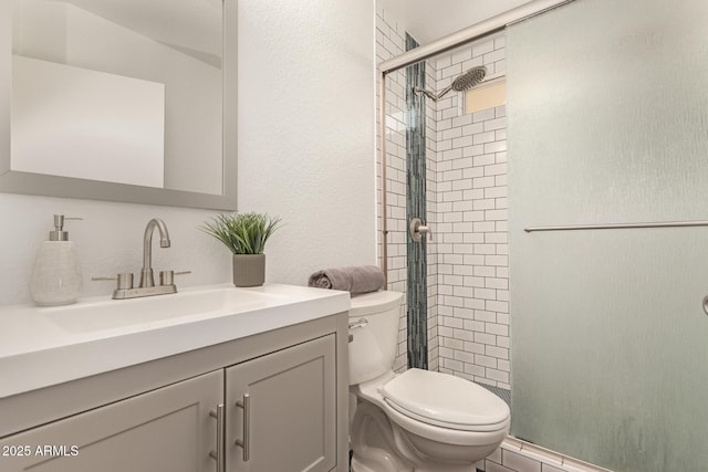 bathroom featuring toilet, a stall shower, and vanity