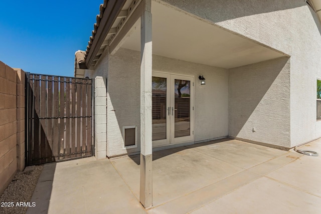 view of patio featuring french doors and fence