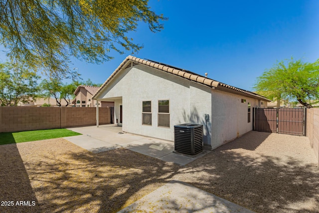 back of property with a patio area, central AC, a fenced backyard, and stucco siding