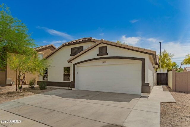mediterranean / spanish-style home with concrete driveway, stucco siding, an attached garage, and a tile roof