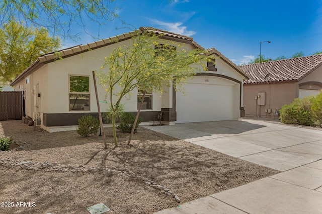 mediterranean / spanish-style house with driveway, stucco siding, an attached garage, and a tile roof
