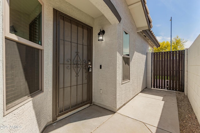 entrance to property with a gate and stucco siding