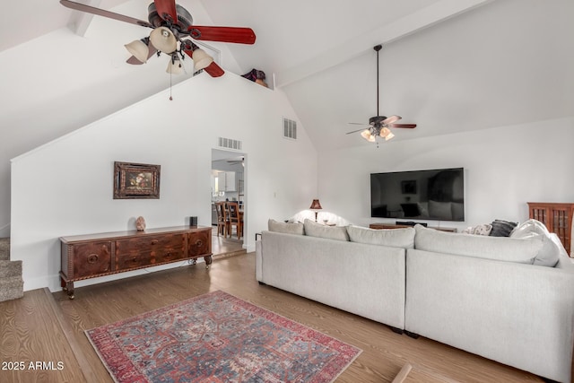 living room featuring hardwood / wood-style flooring, ceiling fan, and beamed ceiling