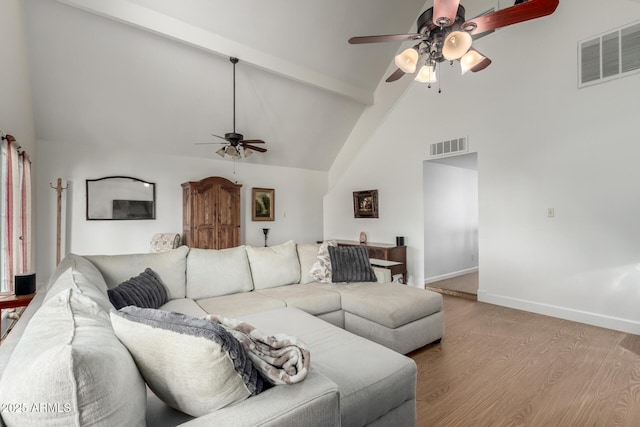 living room featuring high vaulted ceiling, light wood-type flooring, ceiling fan, and beamed ceiling