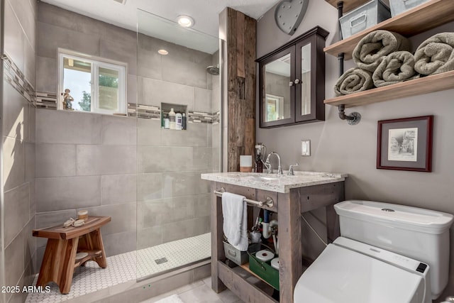 bathroom with a tile shower and vanity