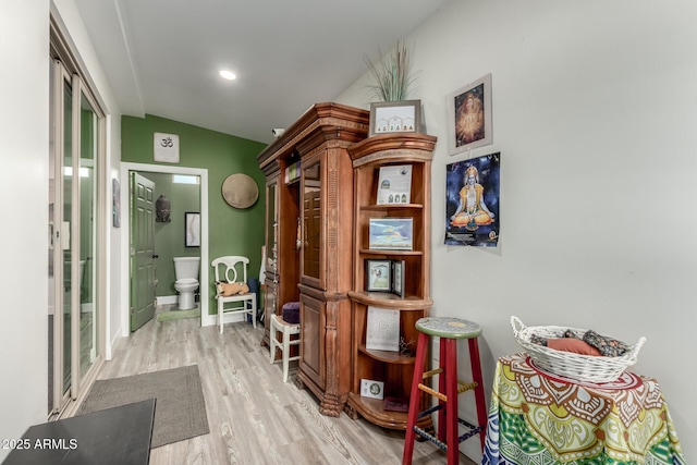 hallway featuring light hardwood / wood-style flooring and lofted ceiling