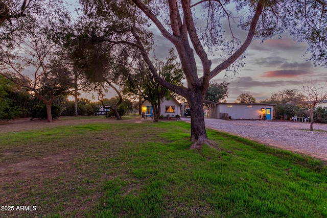 view of property hidden behind natural elements featuring a lawn