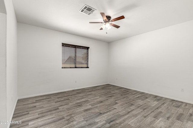 empty room with visible vents, baseboards, ceiling fan, and wood finished floors