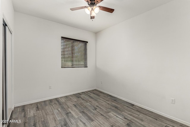 empty room with ceiling fan, baseboards, and wood finished floors