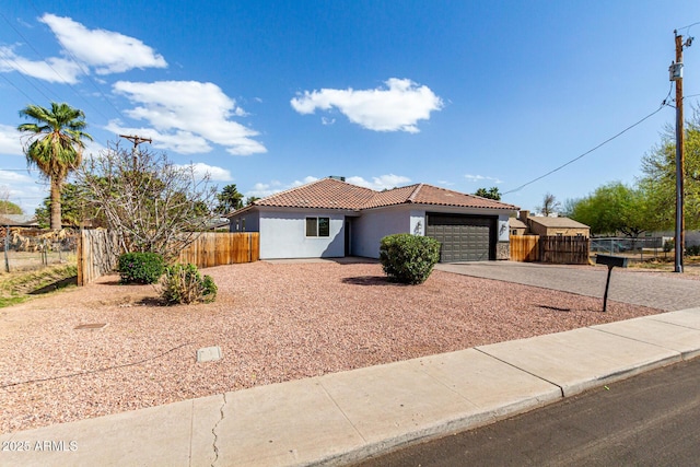 view of front of house featuring stucco siding, a tile roof, fence, concrete driveway, and a garage