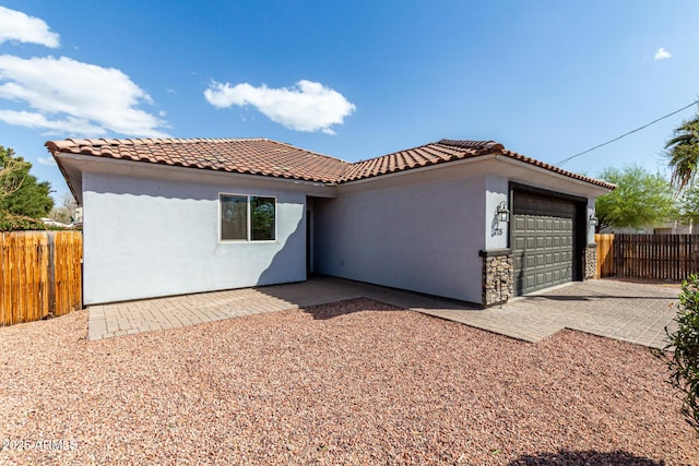 view of front of property with a garage, fence, and a tile roof